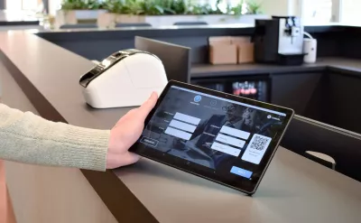 A visitor registering on a tablet for visitor management at a building reception