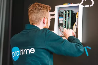 Technician installing and configuring access control hardware inside a wall-mounted unit