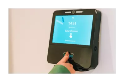 An employee clocking in on a time tracking terminal