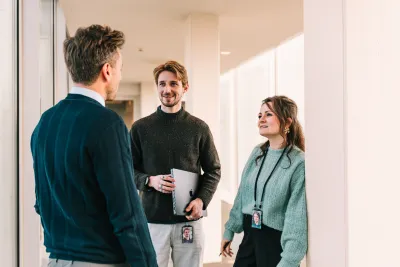 3 collega's die met elkaar aan het praten zijn