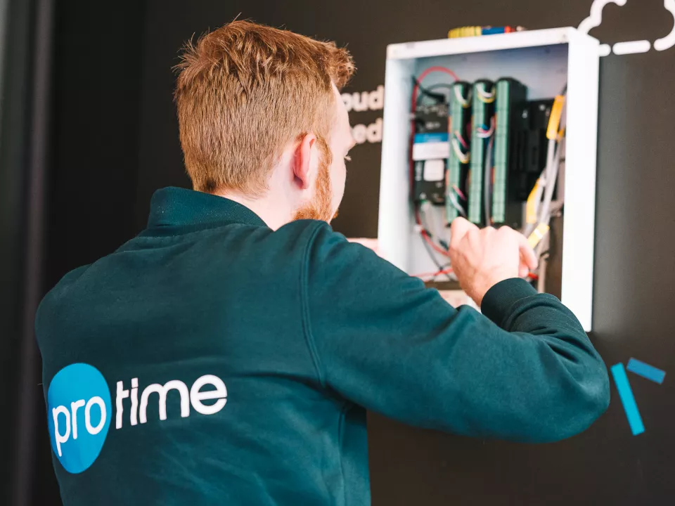 Technician installing and configuring access control hardware inside a wall-mounted unit